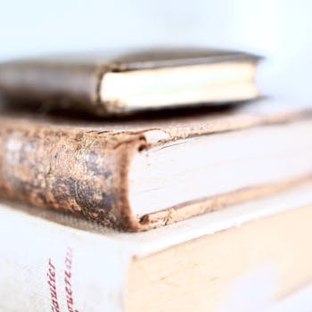 Stack of old books with worn covers, emphasizing vintage charm and literary history.