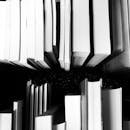 Artistic black and white photo of vertically arranged books viewed from above, showcasing a unique perspective.